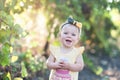 Cute little baby girl in yellow dress standing in the field of g