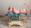 Cute little baby with legs up on scales Royalty Free Stock Photo