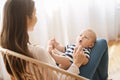 Cute little baby lying on mother`s lap and cooing Royalty Free Stock Photo