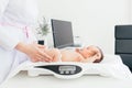 Cute little baby lying on scales, medical checkup in clinic, copy space. Young female pediatrician doctor examines baby girl Royalty Free Stock Photo