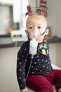 Cute little baby in the mask of an inhaler. Procedure of inhalation at home. Baby taking respiratory therapy with nebulizer Royalty Free Stock Photo