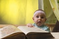 Cute little baby next to a big book Royalty Free Stock Photo