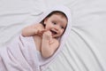 Cute little baby with pacifier in hooded towel after bathing on bed, top view Royalty Free Stock Photo