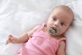 Cute little baby with pacifier lying on bed, top view Royalty Free Stock Photo