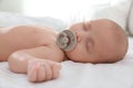 Cute little baby with pacifier sleeping on bed, closeup Royalty Free Stock Photo