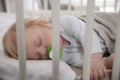 Cute little baby with pacifier sleeping in crib Royalty Free Stock Photo