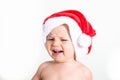 Cute little baby with santa hat is angry and crying isolated on white background. Christmas hate concept, copy space Royalty Free Stock Photo
