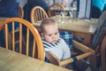 Cute little baby sitting at table in restaurant Royalty Free Stock Photo