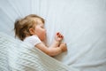 Cute little baby sleeping peacefully on bed at home covered with blanket. Royalty Free Stock Photo