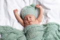 Cute little baby sleeping under knitted plaid in bed, top view Royalty Free Stock Photo