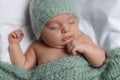 Cute little baby sleeping under knitted plaid in bed, top view Royalty Free Stock Photo