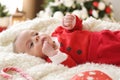 Cute little baby on soft blanket in room decorated for Christmas