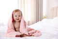 Cute little baby with soft pink towel on bed after bath. Space for text Royalty Free Stock Photo