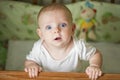 Cute little baby standing in a bed. Smiling child playing in bed. Kid portrait at nursery. Happy childhood concept Royalty Free Stock Photo