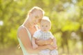 Cute little baby in summer park with mother on the grass. Swee