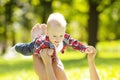 Cute little baby in summer park with mother on the grass. Swee