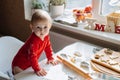 Cute little baby toddler girl making christmas cookies in home kitchen and play with dough. Mother and little girl Royalty Free Stock Photo