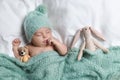 Cute little baby with toys sleeping under knitted plaid in bed, top view Royalty Free Stock Photo