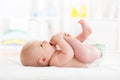 Cute little baby weared diaper playing with his legs and sucking on his foot Royalty Free Stock Photo