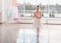 Cute little ballerina in white ballet costume and pointe shoes with is dancing in the room Royalty Free Stock Photo