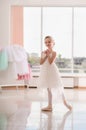 Cute little ballerina in white dress and pointe shoes dreams about ballet dances Royalty Free Stock Photo