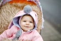 Cute little beautiful baby girl sitting in the pram or stroller on autumn day. Happy smiling child in warm clothes Royalty Free Stock Photo