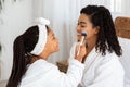 Cute Little Black Girl Applying Makeup With Brush To Her Beautiful Mom Royalty Free Stock Photo