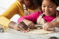 Cute little black girl making cookies with mom in kitchen together Royalty Free Stock Photo