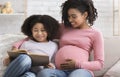 Cute Little Black Girl Reading Book With Pregnant Mom At Home Royalty Free Stock Photo