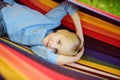 Cute little blond caucasian boy having fun with multicolored hammock in backyard or outdoor playground. Summer outdoors active Royalty Free Stock Photo