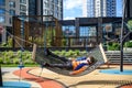 Cute little blond caucasian boy relaxing and having fun in multicolored hammock in backyard or outdoor playground. Summer active Royalty Free Stock Photo