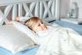 Cute little blond caucasian girl awakening at bed in morning. Child wake up early to go to school. Stretching and yawning. Healthy Royalty Free Stock Photo