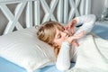 Cute little blond caucasian girl awakening at bed in morning. Child wake up early to go to school. Stretching and Royalty Free Stock Photo