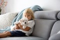 Cute little blond child, toddler boy, playing with white puppy maltese dog Royalty Free Stock Photo