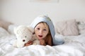 Cute little toddler boy, relaxing in bed after bath, smiling happily, daytime Royalty Free Stock Photo