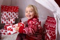 Cute little blonde boy with Christmas sweater, opening presents at home Royalty Free Stock Photo