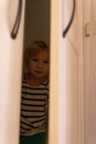 Cute little blonde boy hiding in a closet Royalty Free Stock Photo