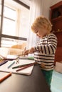Cute little blonde boy playing with color pencils Royalty Free Stock Photo