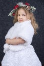 Cute little blonde girl in a beautiful white dress on a dark background Royalty Free Stock Photo