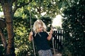 Cute little blonde girl playing on a tree swing outside Royalty Free Stock Photo