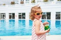 Cute little blonde at the pool and holding a child`s cocktail