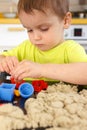 Cute little boy age of 3 years plays kinetic sand at home Royalty Free Stock Photo