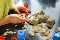 Cute little boy age of 3 years plays kinetic sand at home. Occupation with a child in quarantine Royalty Free Stock Photo