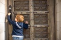Cute little boy baby knocking on old door Royalty Free Stock Photo