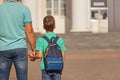 Cute little boy with backpack going to school with his father. Back view. Royalty Free Stock Photo