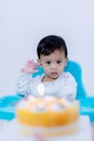 Cute little boy with birthday cake sitting on chair in room . Royalty Free Stock Photo