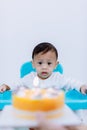 Cute little boy with birthday cake sitting on chair in room . Royalty Free Stock Photo