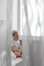 A cute little boy with blond hair listens to music in white headphones. Royalty Free Stock Photo