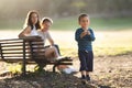 Cute little boy blowing soap bubbles with his parents behind his back looking for him Royalty Free Stock Photo