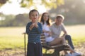 Cute little boy blowing soap bubbles with his parents behind his back Royalty Free Stock Photo